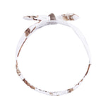 Baby knot headband in a wild horses print, showing the classic center knot detail.