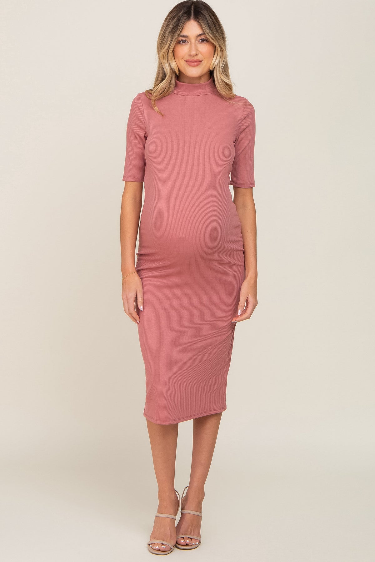 Mauve ribbed maternity midi dress with a mock neck and short sleeves on a pregnant woman.