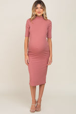 Mauve ribbed maternity midi dress with a mock neck and short sleeves on a pregnant woman.