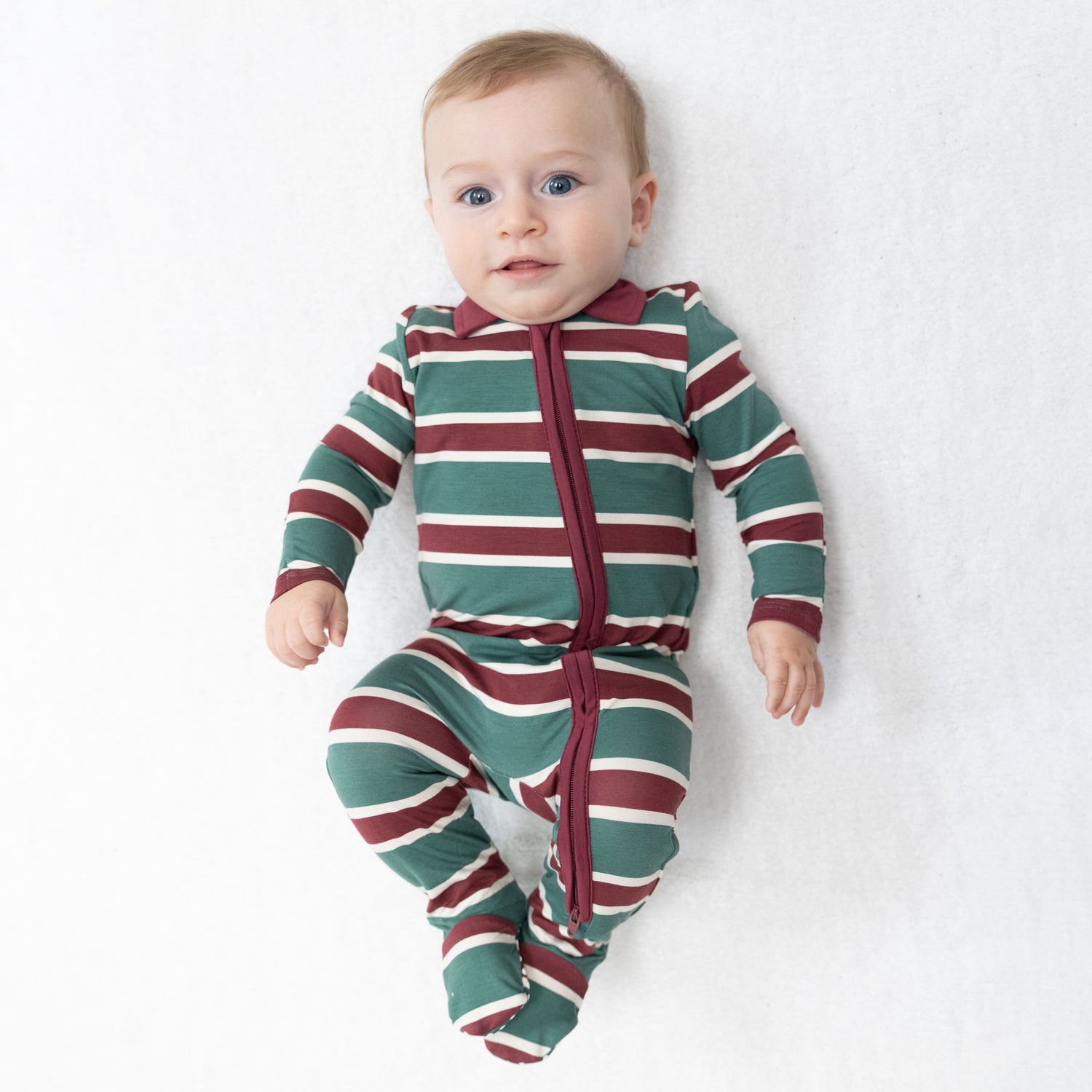 Footie pajamas with green rugby stripes, a collared polo neckline, and a full-length two-way zipper.