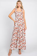 Cream floral maxi dress with smocked shoulder tie straps and a flowing tiered skirt.