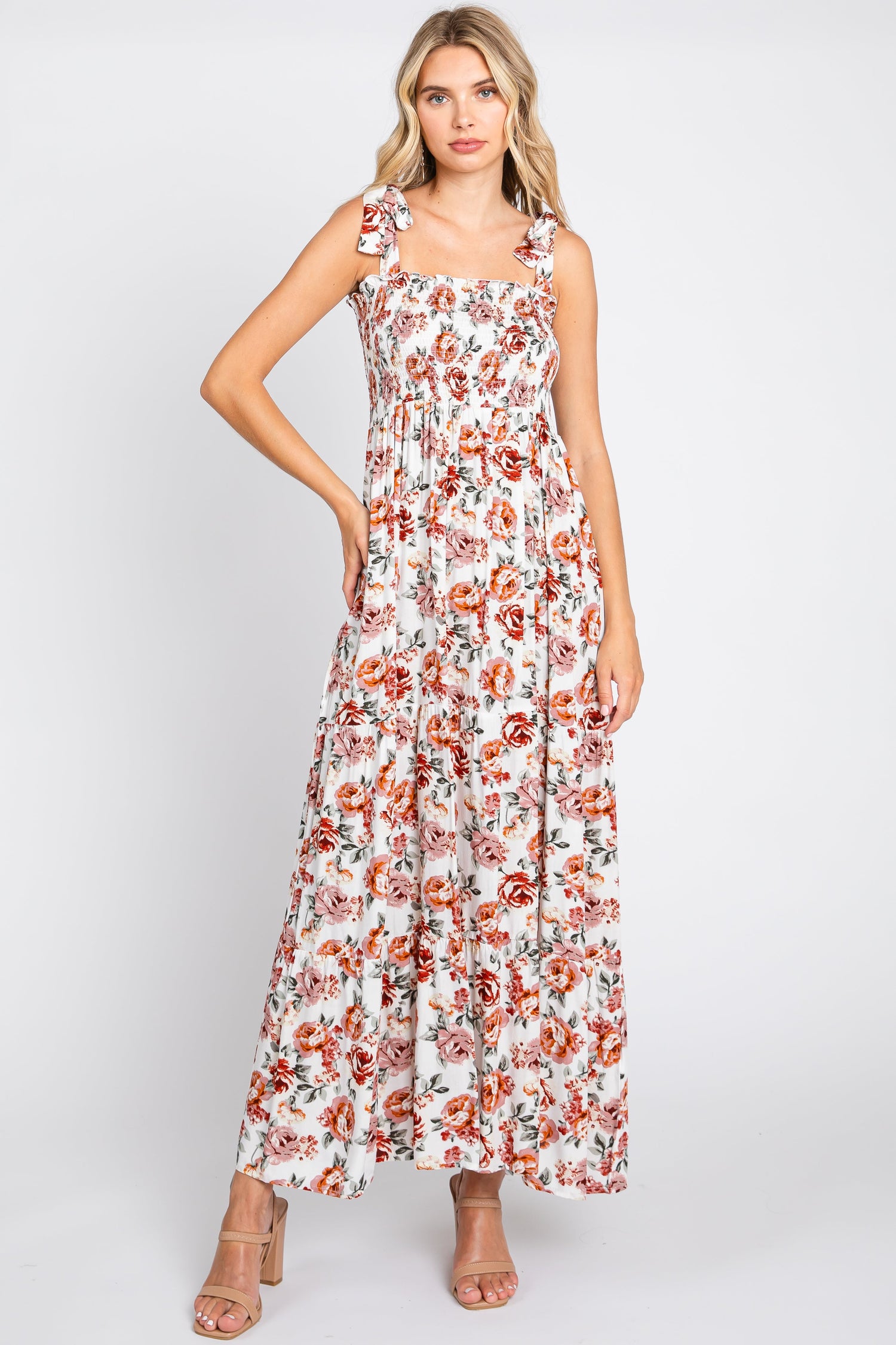 Cream floral maxi dress with smocked shoulder tie straps and a flowing tiered skirt.