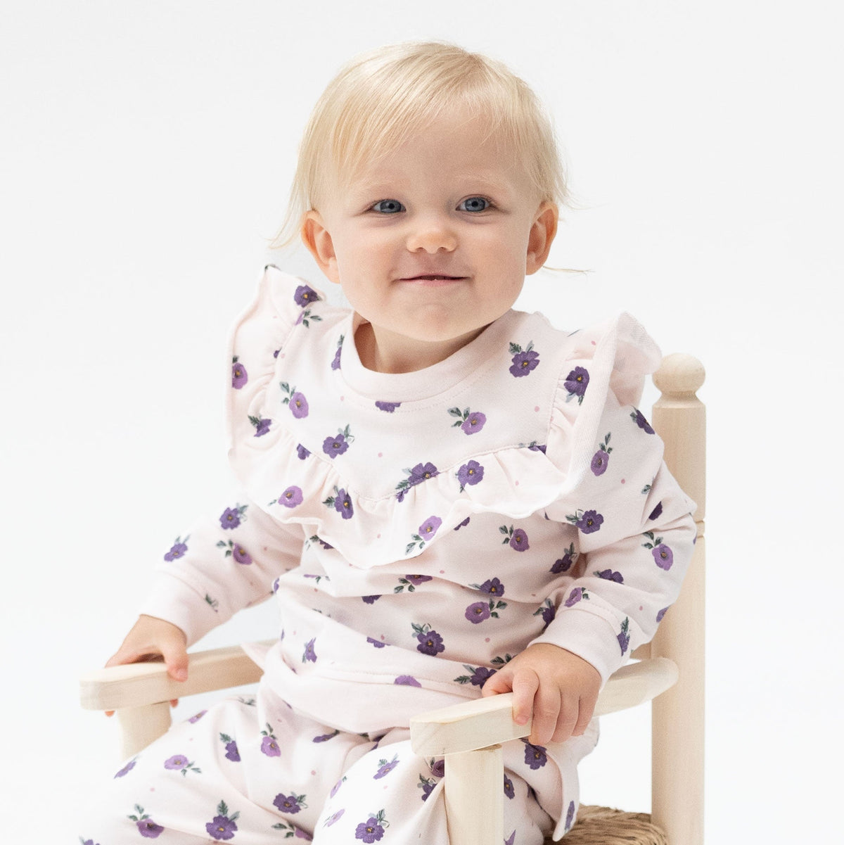 Baby and toddler sweatshirt in a violet floral print with ruffle trim along the V-shaped neckline