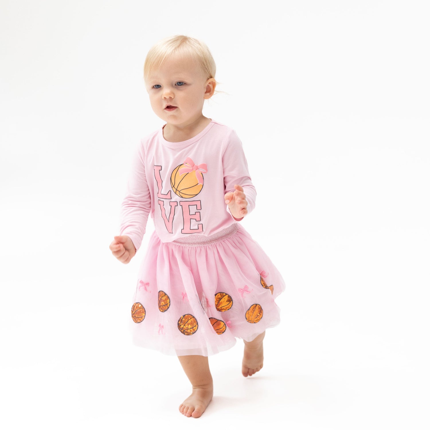 Pink tutu skirt with tulle overlay, sequin basketball and bow appliques, and matching bike shorts underneath.