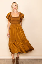 Camel satin midi dress with flutter sleeves, square neckline, smocked top and ruffle hem, styled with heels.