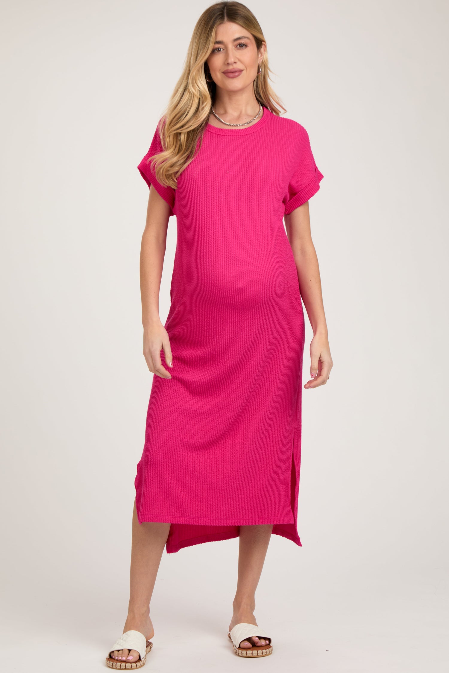 Fuchsia ribbed maternity midi dress with short cuffed sleeves, rounded neckline, and side slits.