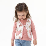 Quilted baby vest with heart-shaped pockets in a cowgirl cameo print