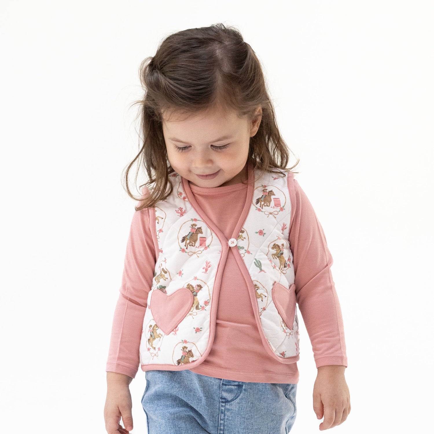 Quilted baby vest with heart-shaped pockets in a cowgirl cameo print