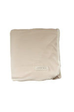 Oat ribbed toddler blanket in a neutral oatmeal tone, laid flat to show its ribbed texture.