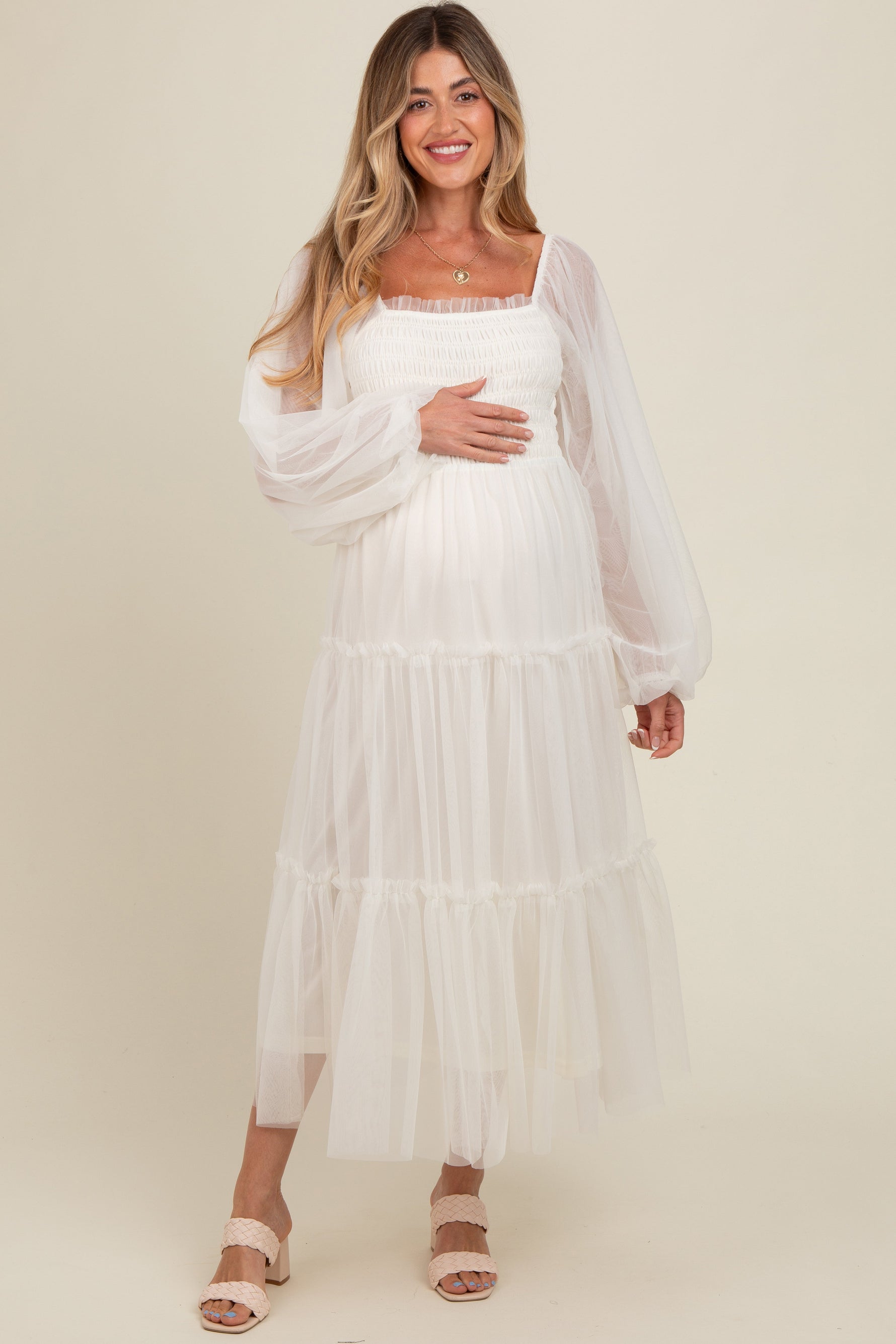 Woman modeling a PinkBlush Cream Mesh Tiered Long Sleeve Maternity Maxi Dress, looking elegant.