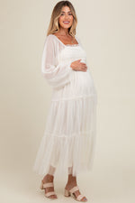 Woman modeling a PinkBlush Cream Mesh Tiered Long Sleeve Maternity Maxi Dress, looking elegant.