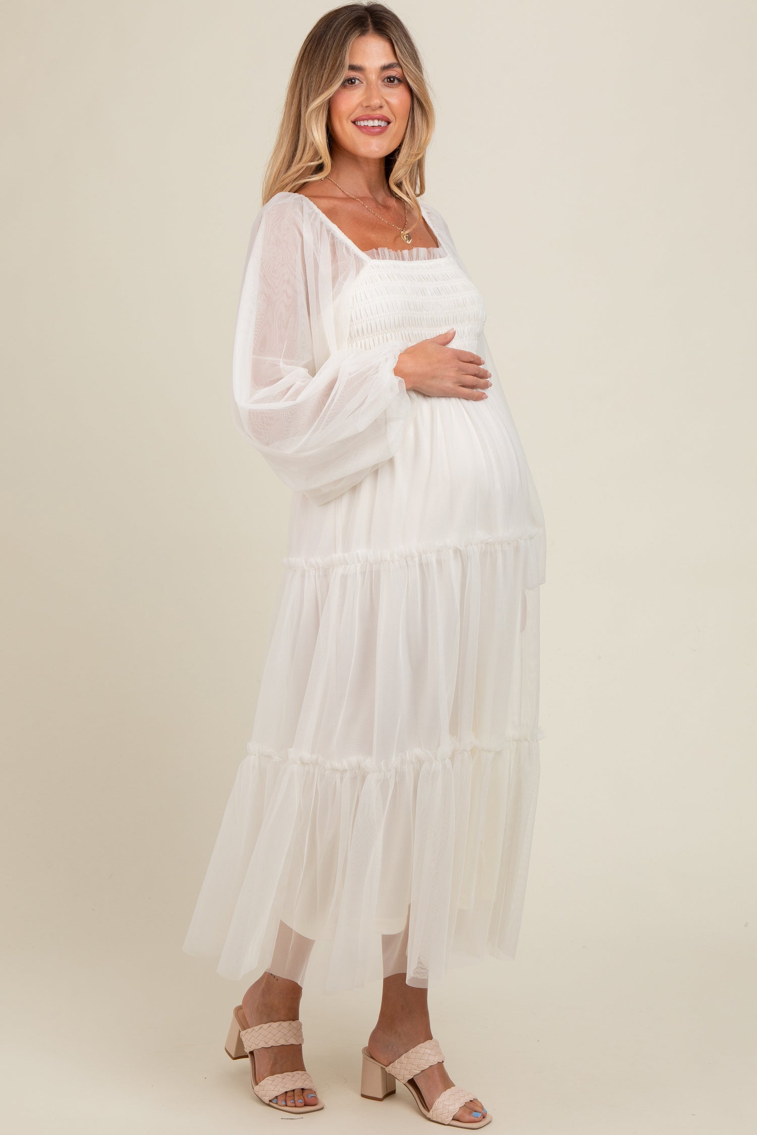 Woman modeling a PinkBlush Cream Mesh Tiered Long Sleeve Maternity Maxi Dress, looking elegant.
