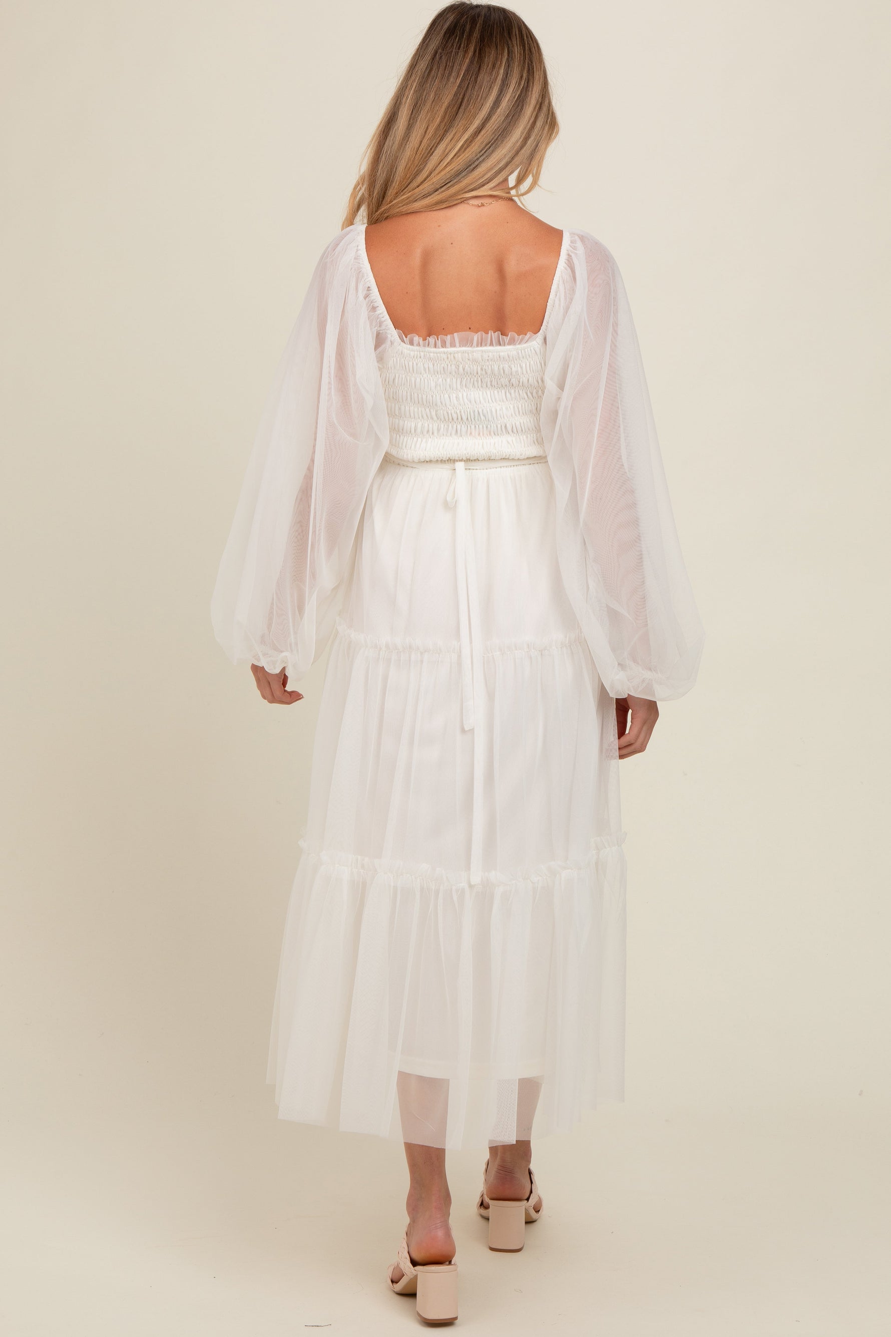 Woman modeling a PinkBlush Cream Mesh Tiered Long Sleeve Maternity Maxi Dress, looking elegant.