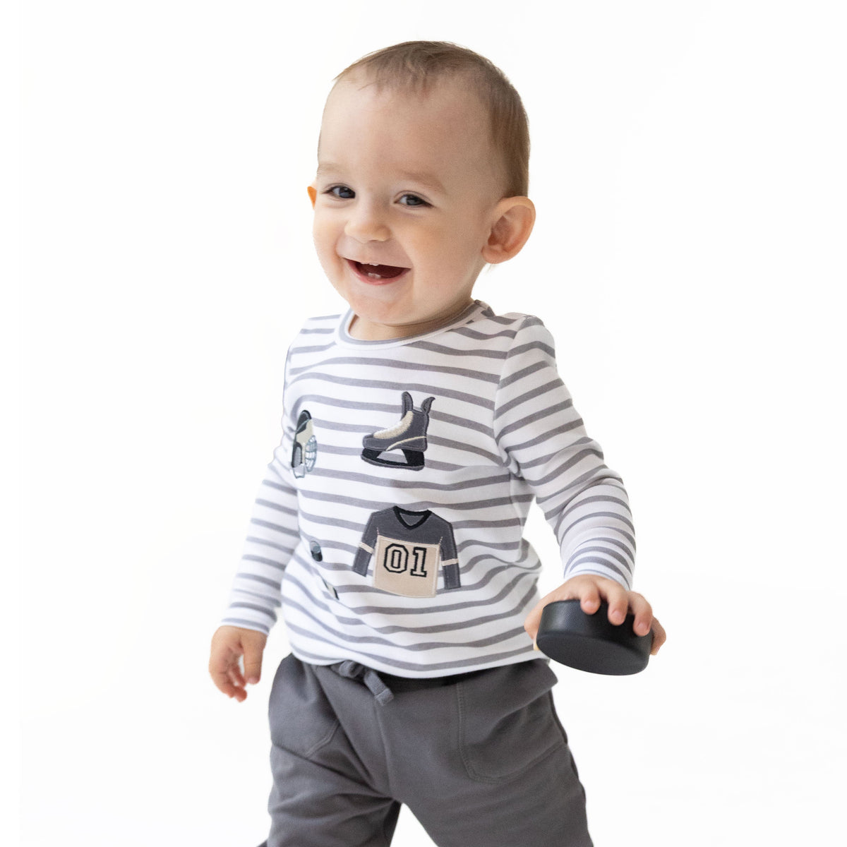 Long sleeve children's shirt with hockey appliques including pucks, sticks and skates