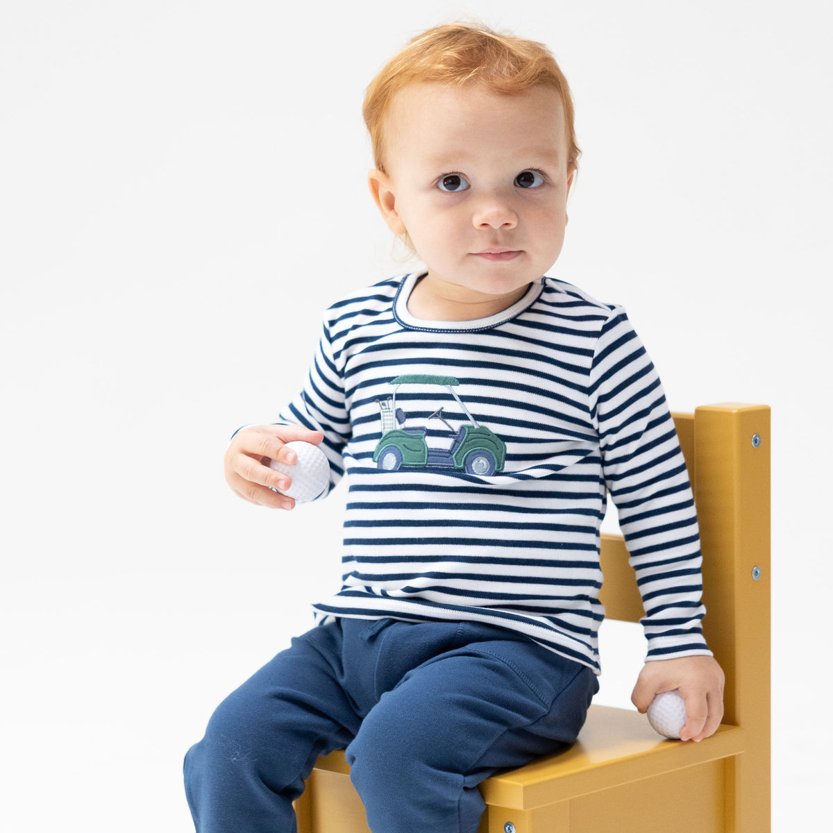 Green long sleeve baby shirt with a golf cart applique on the front