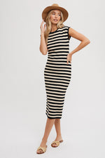 Sleeveless black striped midi dress with a rounded neckline, worn with a sun hat and sandals.