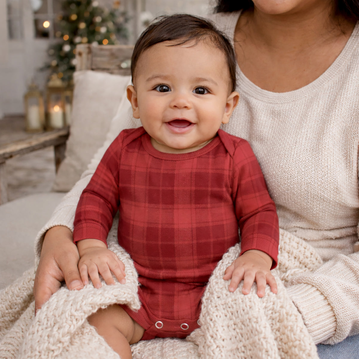 Red plaid baby bodysuit with envelope neckline and snap closures at the legs
