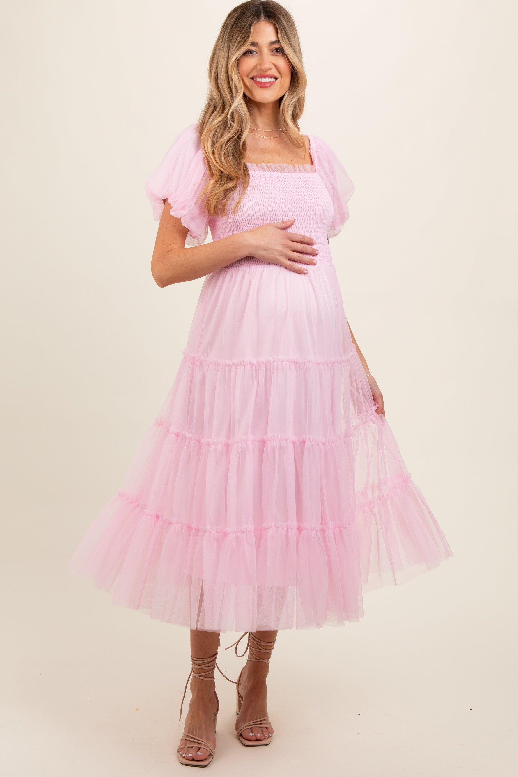 Light pink smocked tiered tulle maternity midi dress with fitted bodice and full skirt