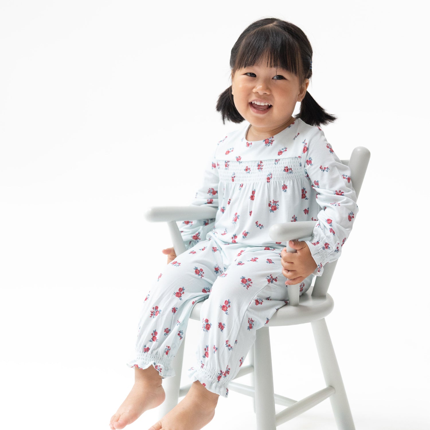 Long sleeve baby romper in Alyssa floral print with smocked detailing across the chest.
