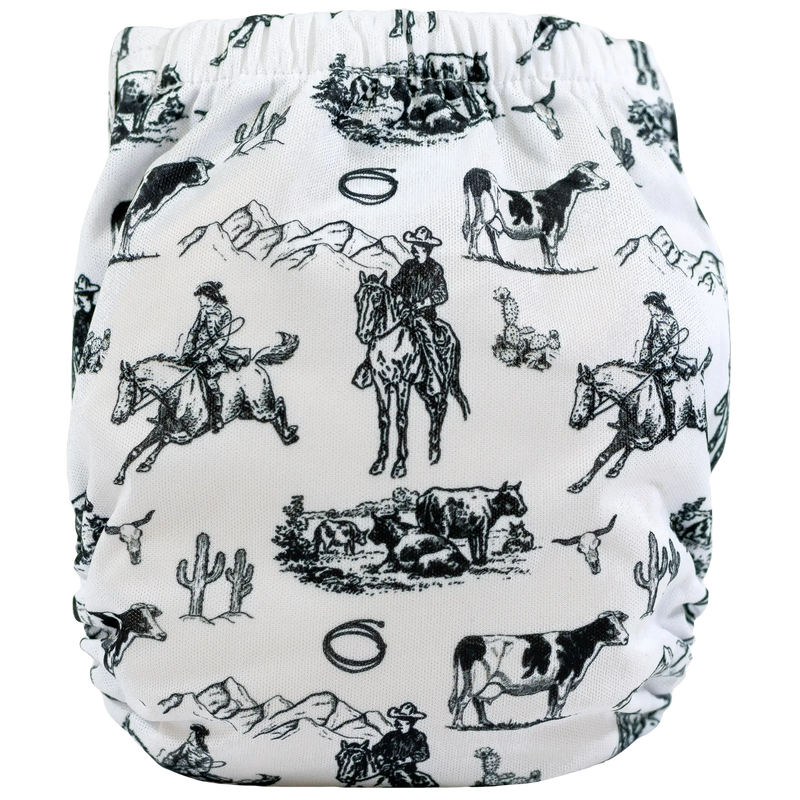 Tiny Tushies Newborn AIO cloth diaper with cowboy and cattle illustrations, featuring secure snaps and pocket opening for extra absorbency.