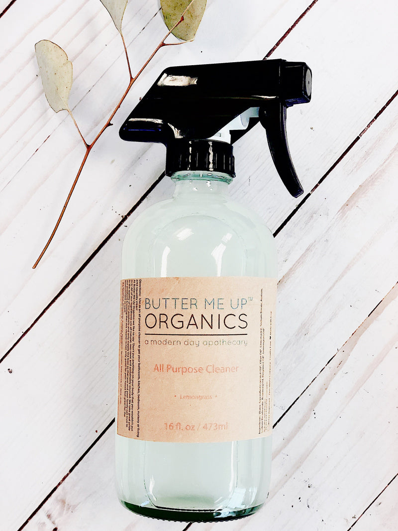 Natural All Purpose Cleaner Organic in glass bottle with spray pump on white wooden surface.