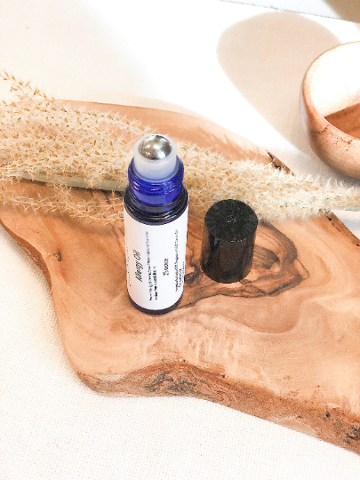 Organic Allergy Oil roll-on for natural allergy relief on a wooden tray.