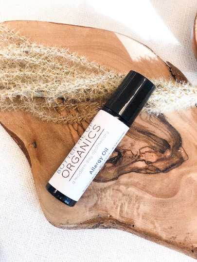 Organic Allergy Oil roll-on for natural allergy relief on wooden surface.