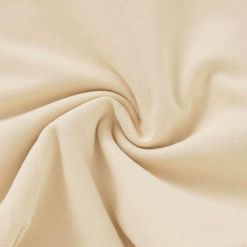 Cream-colored French Terry fabric with smooth texture for baby overalls.