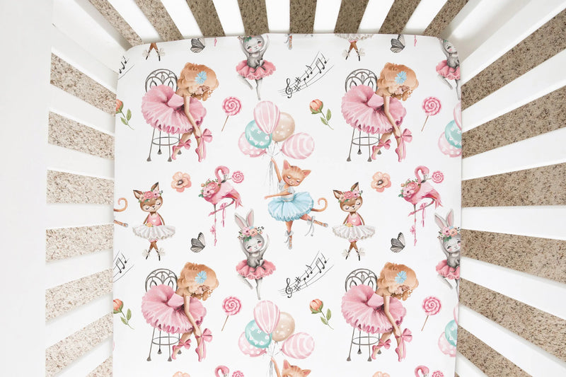 Ballerina-themed fitted crib sheet with whimsical animal illustrations in a crib.