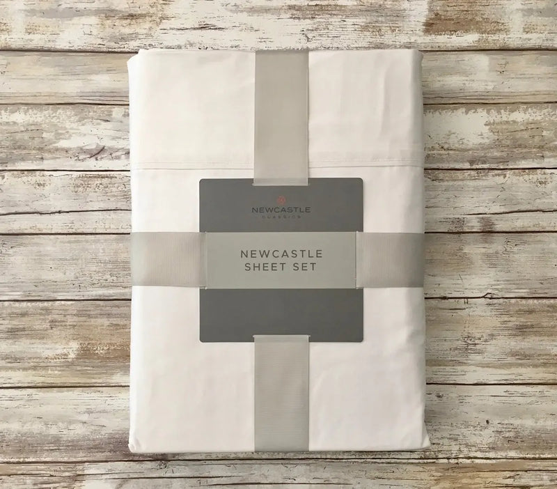 Bamboo sheet set packaged on a wooden background, Newcastle brand label visible.