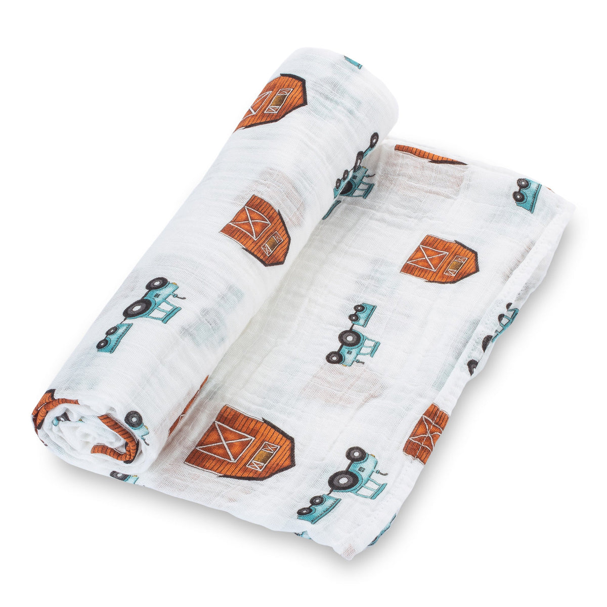 Organic cotton muslin swaddle blanket printed with tractors and barns, spread flat to show the farm design