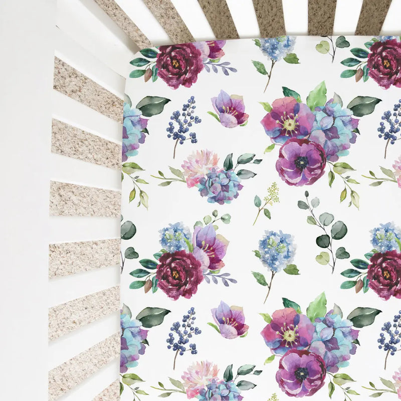 Blue floral fitted crib sheet with unique pattern in a crib.
