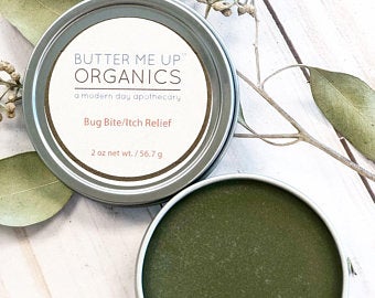 Organic bug bite and anti-itch cream in an open tin container.