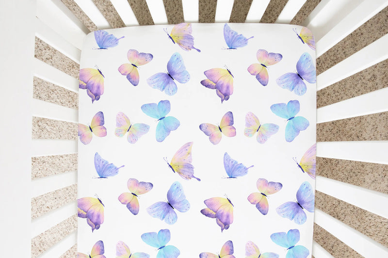 Butterfly pattern fitted crib sheet in a nursery setting.