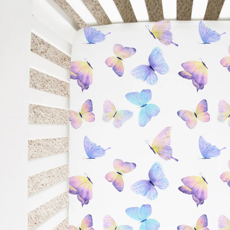 Butterfly patterned fitted crib sheet on a crib mattress.