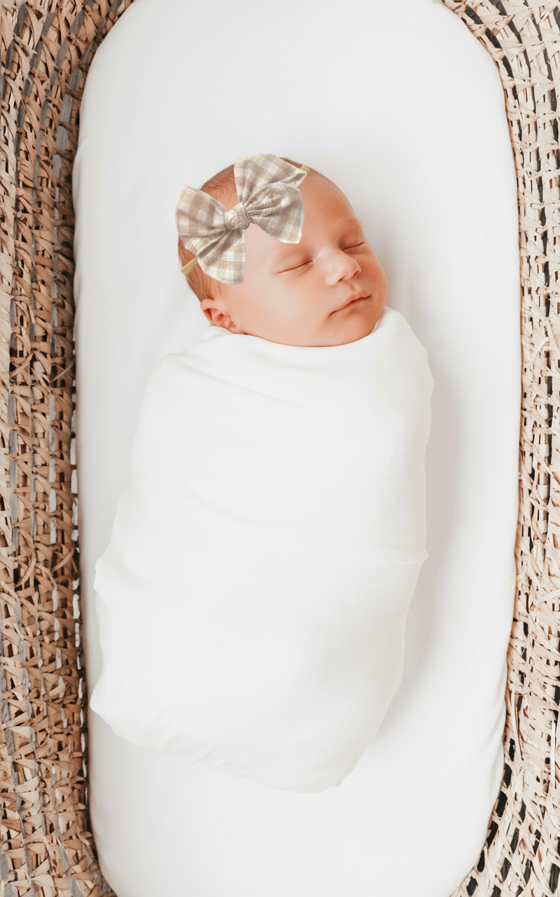 Little Mae & Co white sailor bow headband and clip on a baby, suitable for newborns to girls.