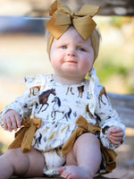 Long-sleeve girls romper with Western horse print, ruffle trim, and a bow accent.