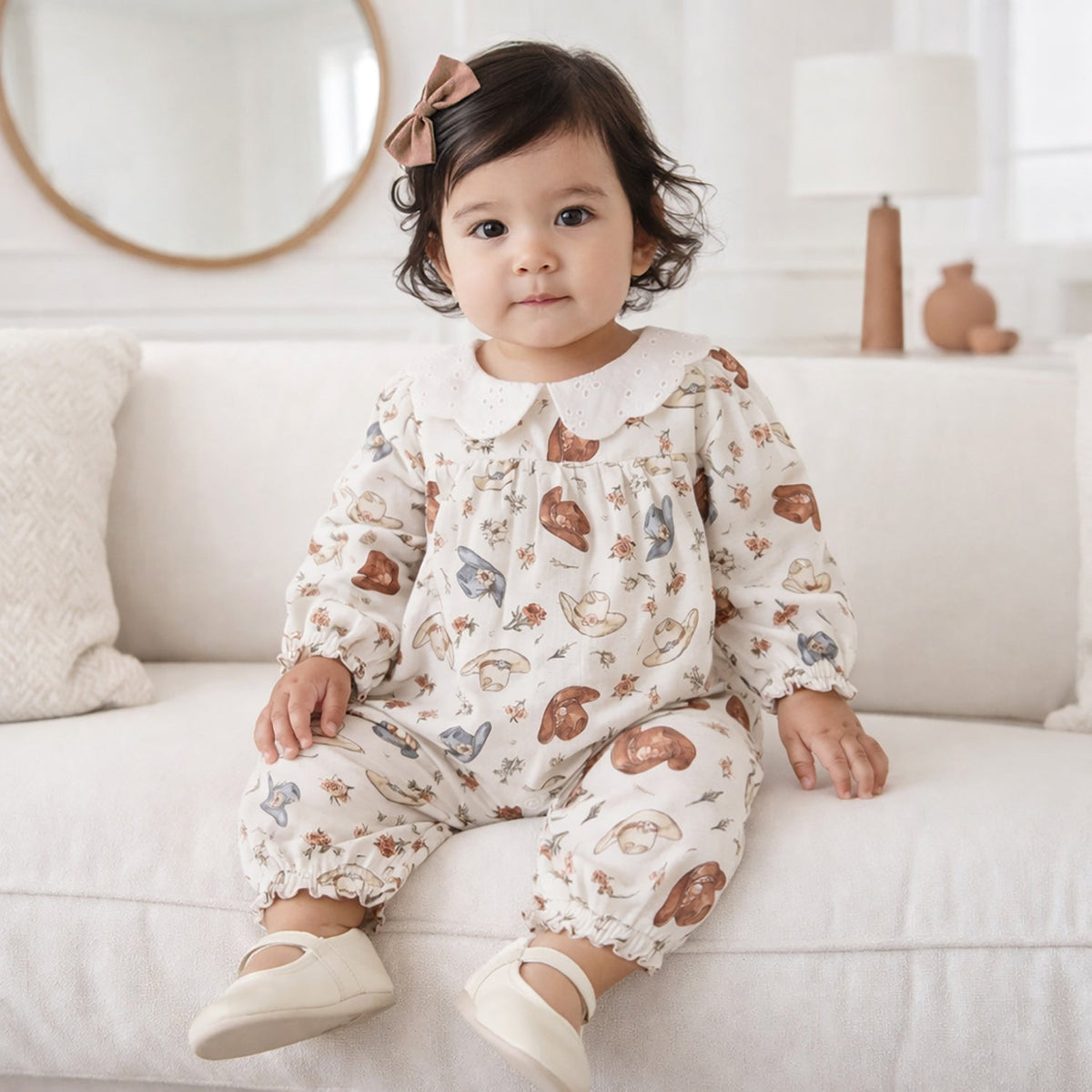 Baby romper with all-over cowgirl hat print in soft vintage tones, scalloped eyelet collar and ruffled leg hems