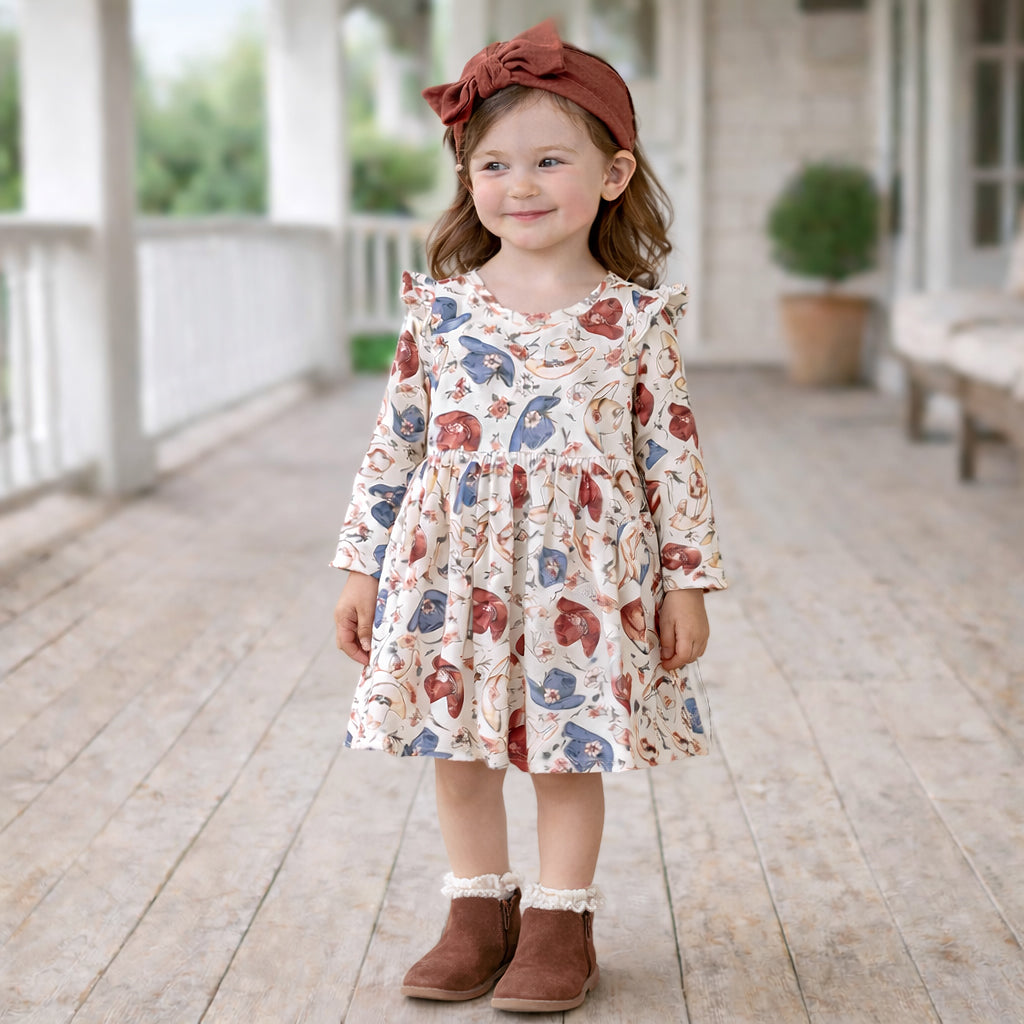 Cowgirl twirl dress with cowboy hat and floral print, ruffle-trimmed sleeves, gathered skirt, and button-back closure.