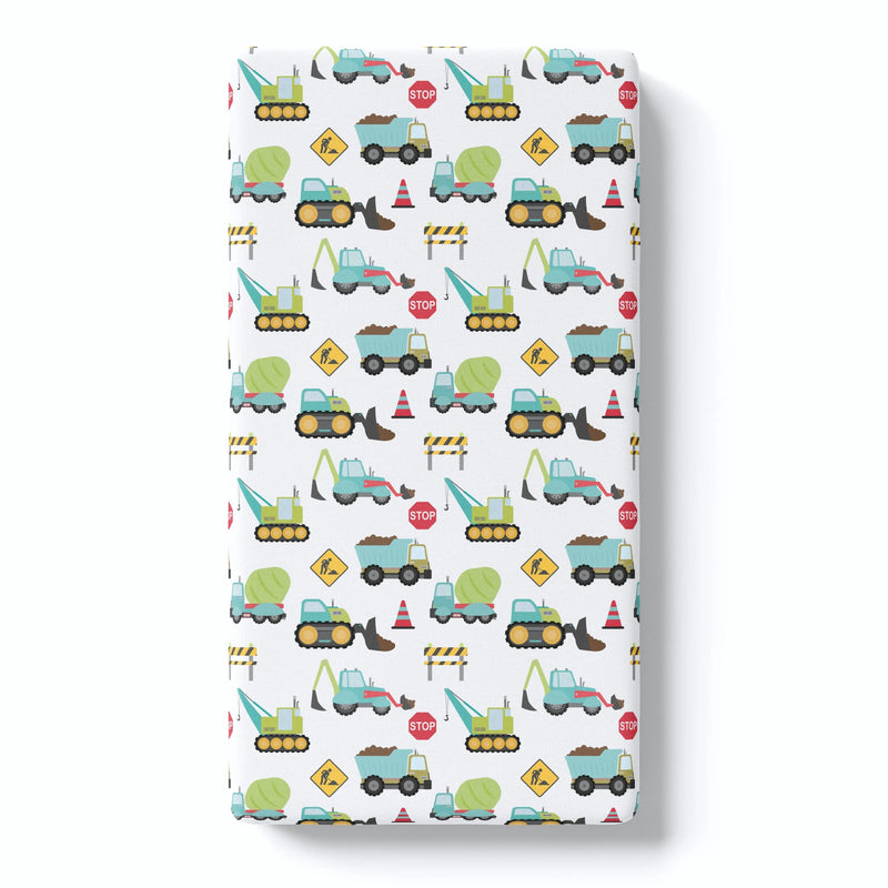Fitted crib sheet featuring construction truck pattern on white background.