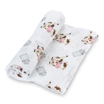 Organic cotton muslin swaddle blanket printed with spotted cows and milk pails