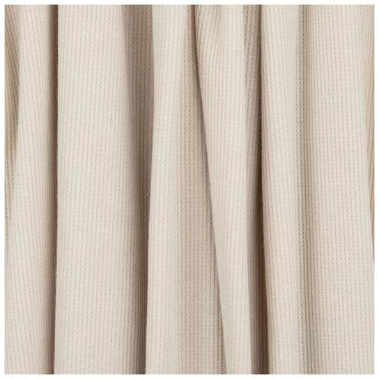 Close-up of a soft ivory coco waffle changing pad cover by Little Mae & Co. on a changing table.