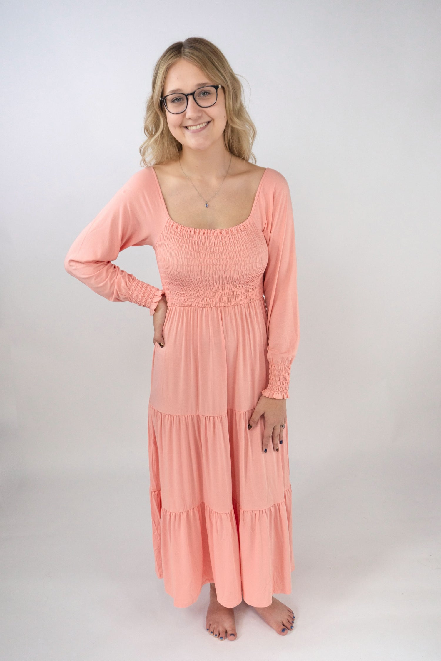 Peach long sleeve dress with a smocked bodice and flowy sleeves.