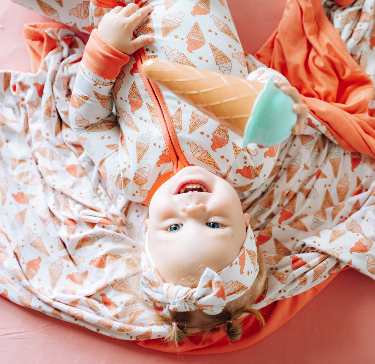 Organic Ice Cream Dreams Bow on a happy baby, showcasing the sweet print and soft fabric