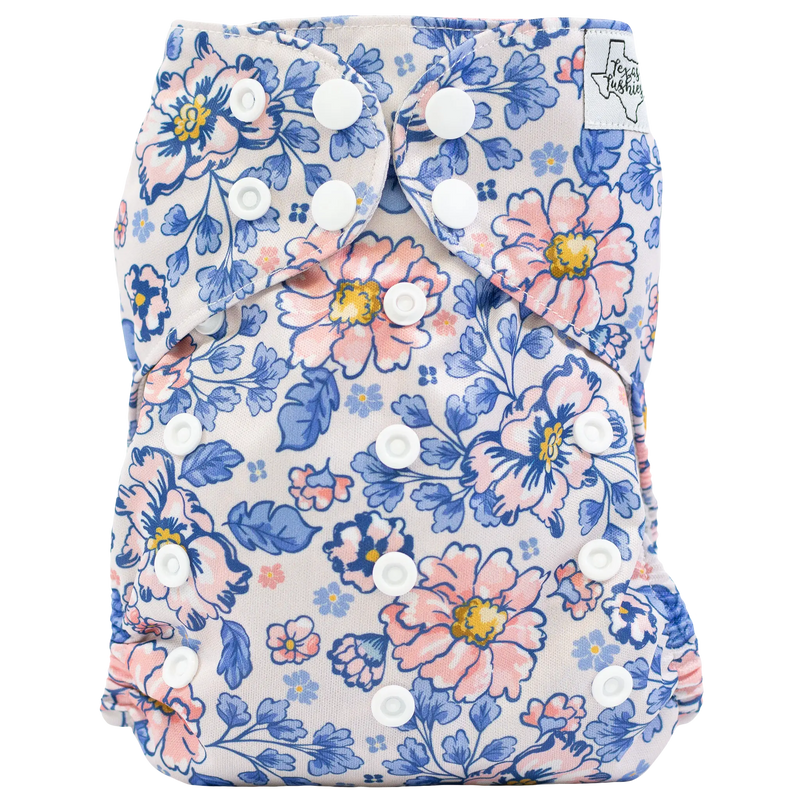 Slim fit pocket cloth diaper with floral print and adjustable snaps.