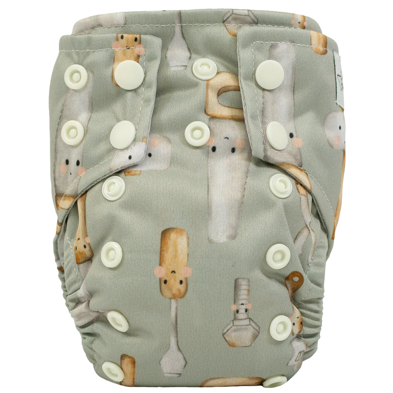 Tiny Tushies Newborn AIO Cloth Diaper with snaps and printed design.