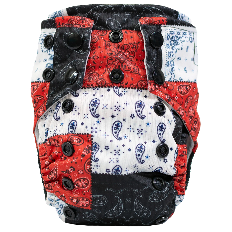 Tiny Tushies Newborn AIO cloth diaper with colorful patterned design and secure closure snaps.