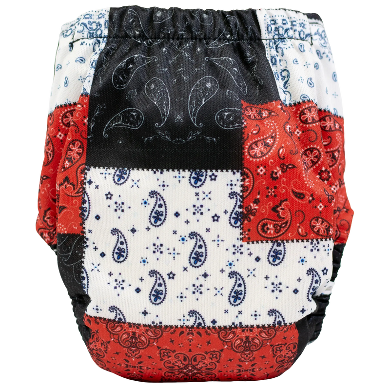 Tiny Tushies Newborn AIO cloth diaper with colorful patchwork design, fits 5-20 lbs.