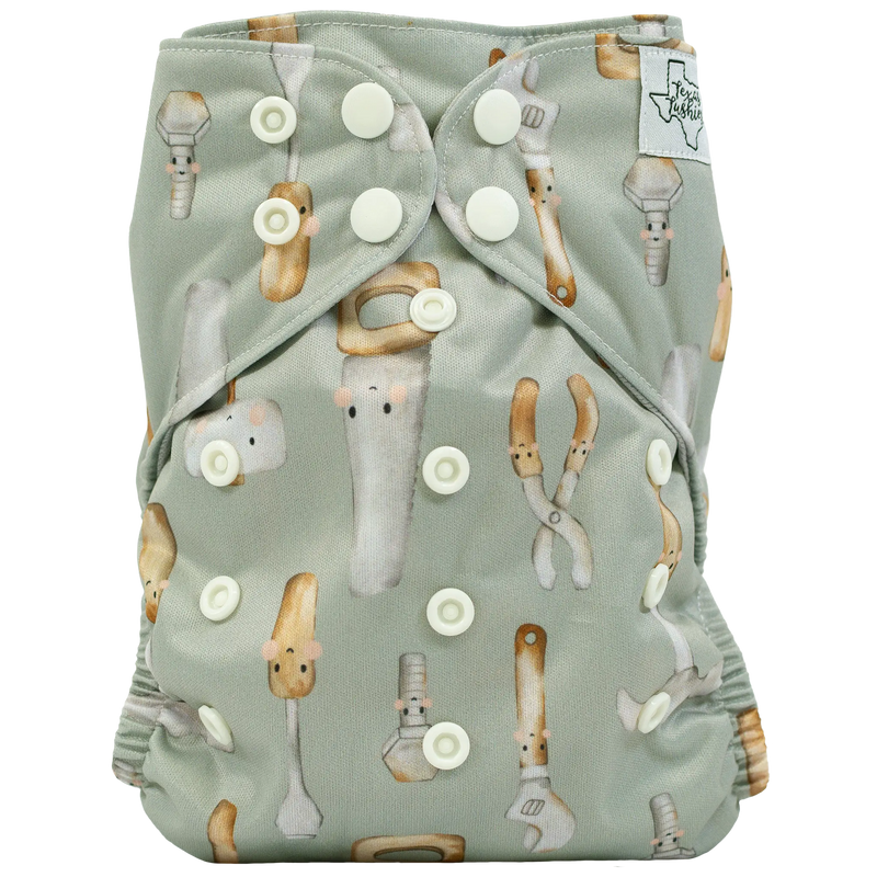 Slim fit pocket cloth diaper with tool-themed print and adjustable snaps.
