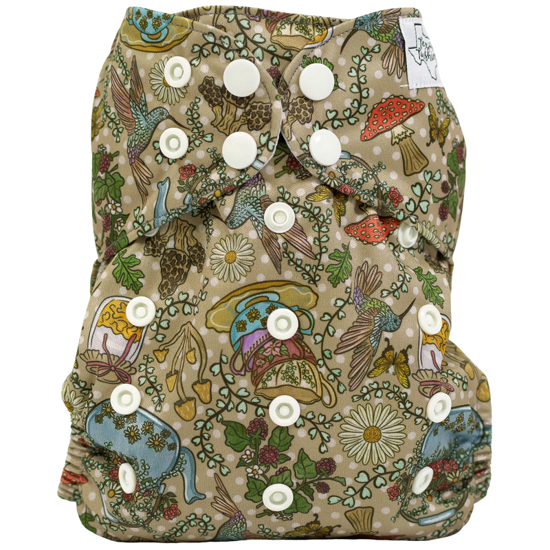 Slim fit AIO cloth diaper with colorful nature-themed pattern and adjustable snaps.
